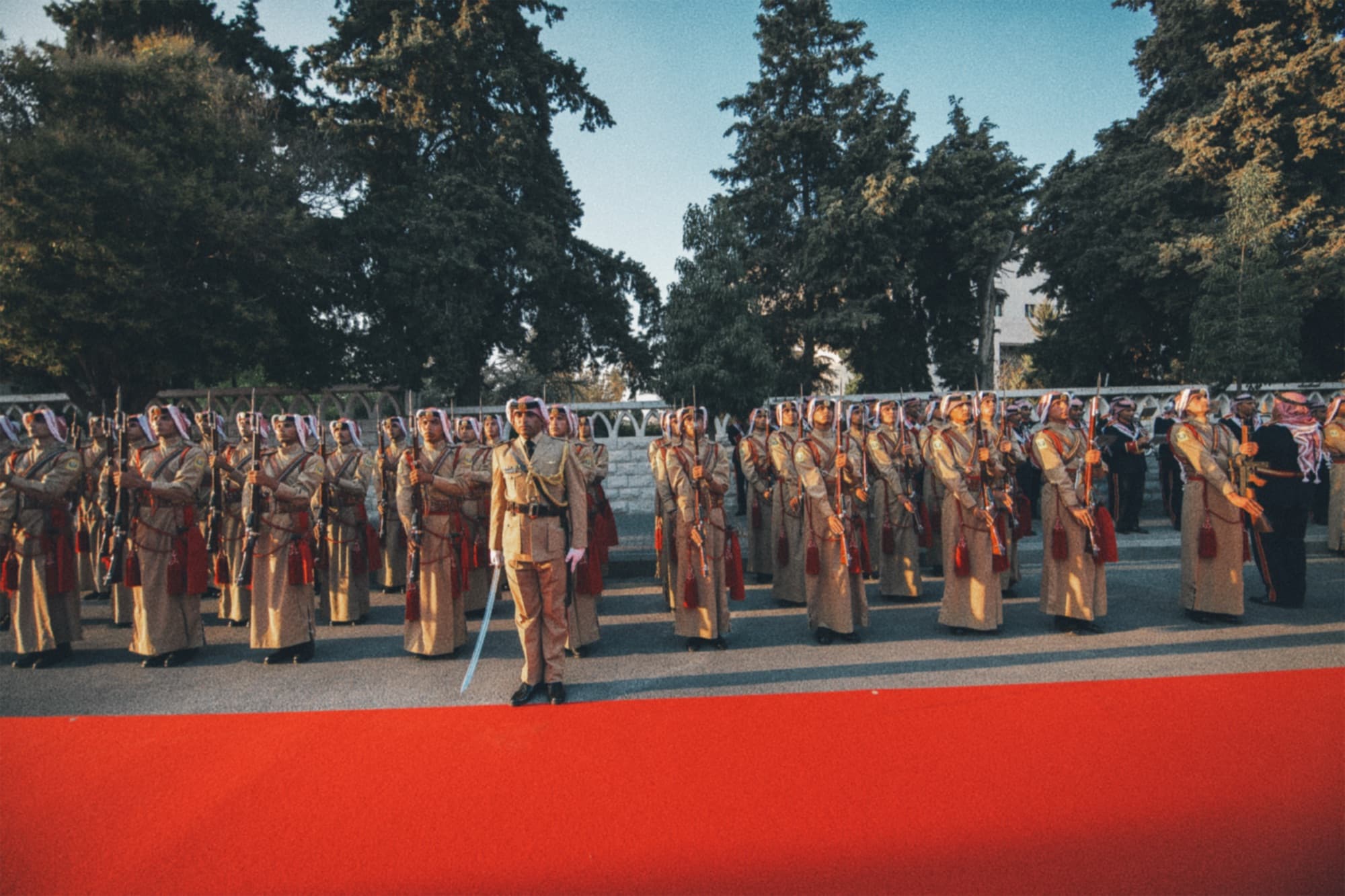 An honour guard standing beside a red carpet