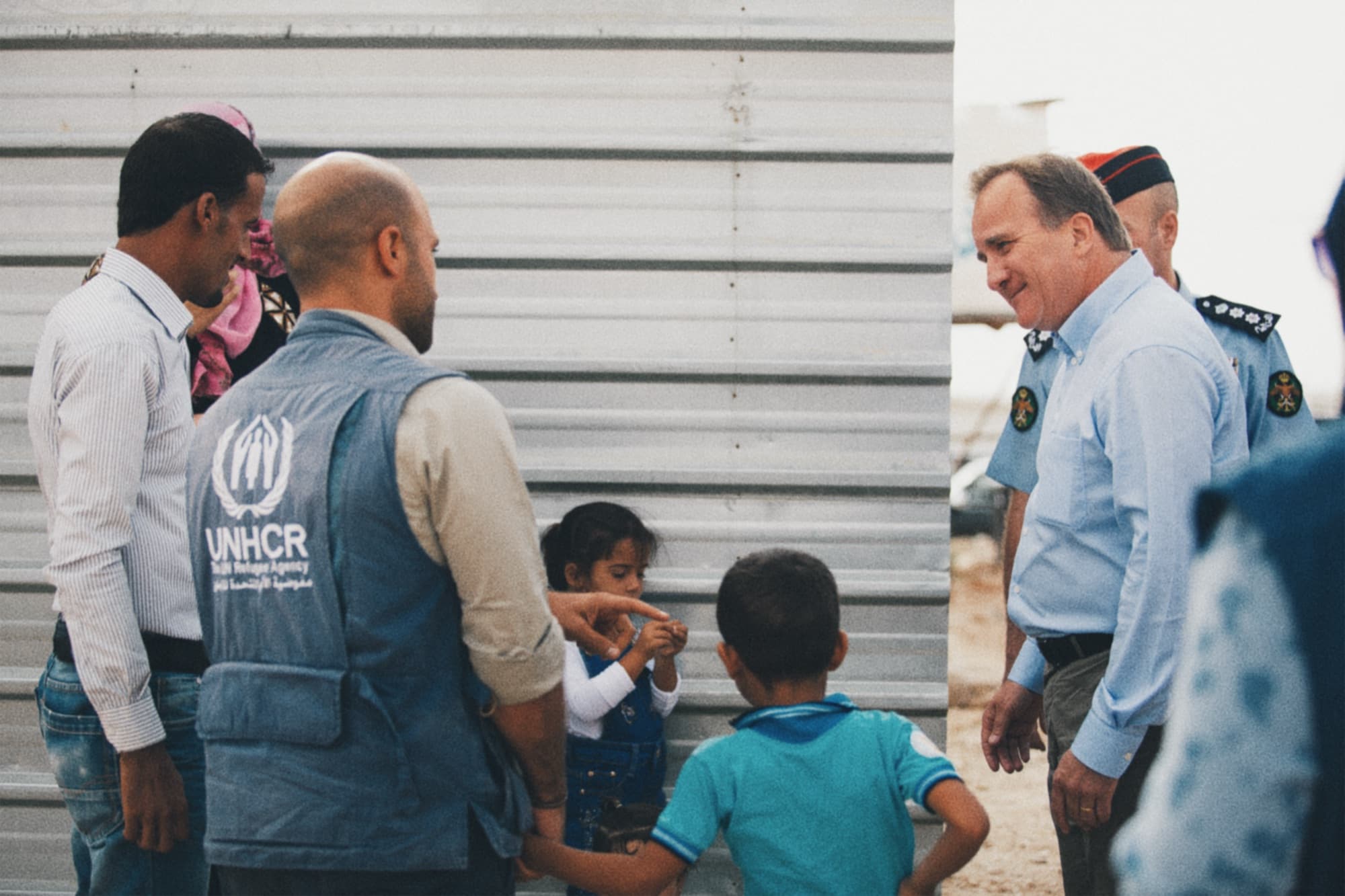 A delegation speaking with UNHCR staff outside a shelter