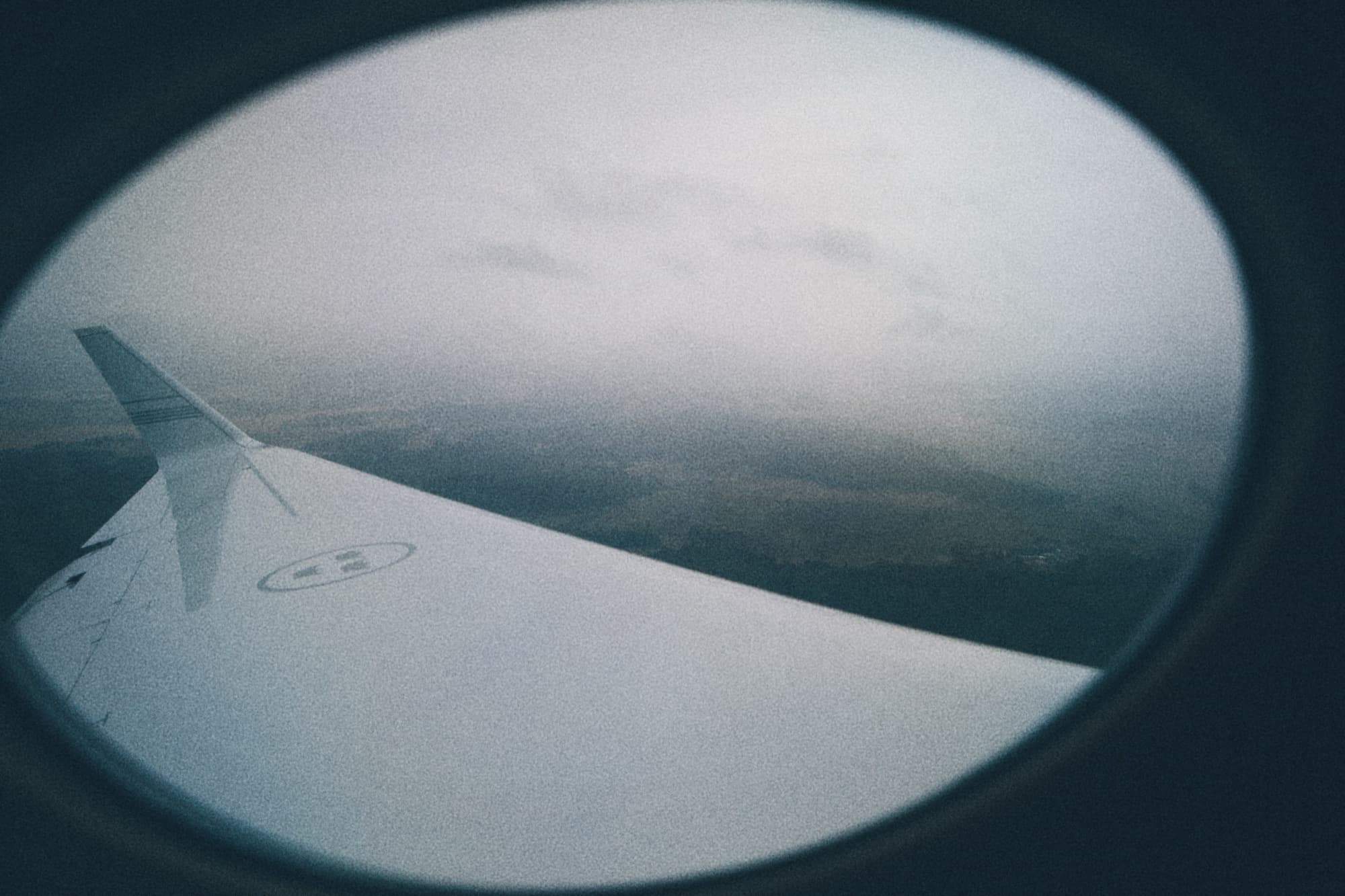 An aircraft wing seen through a cabin window