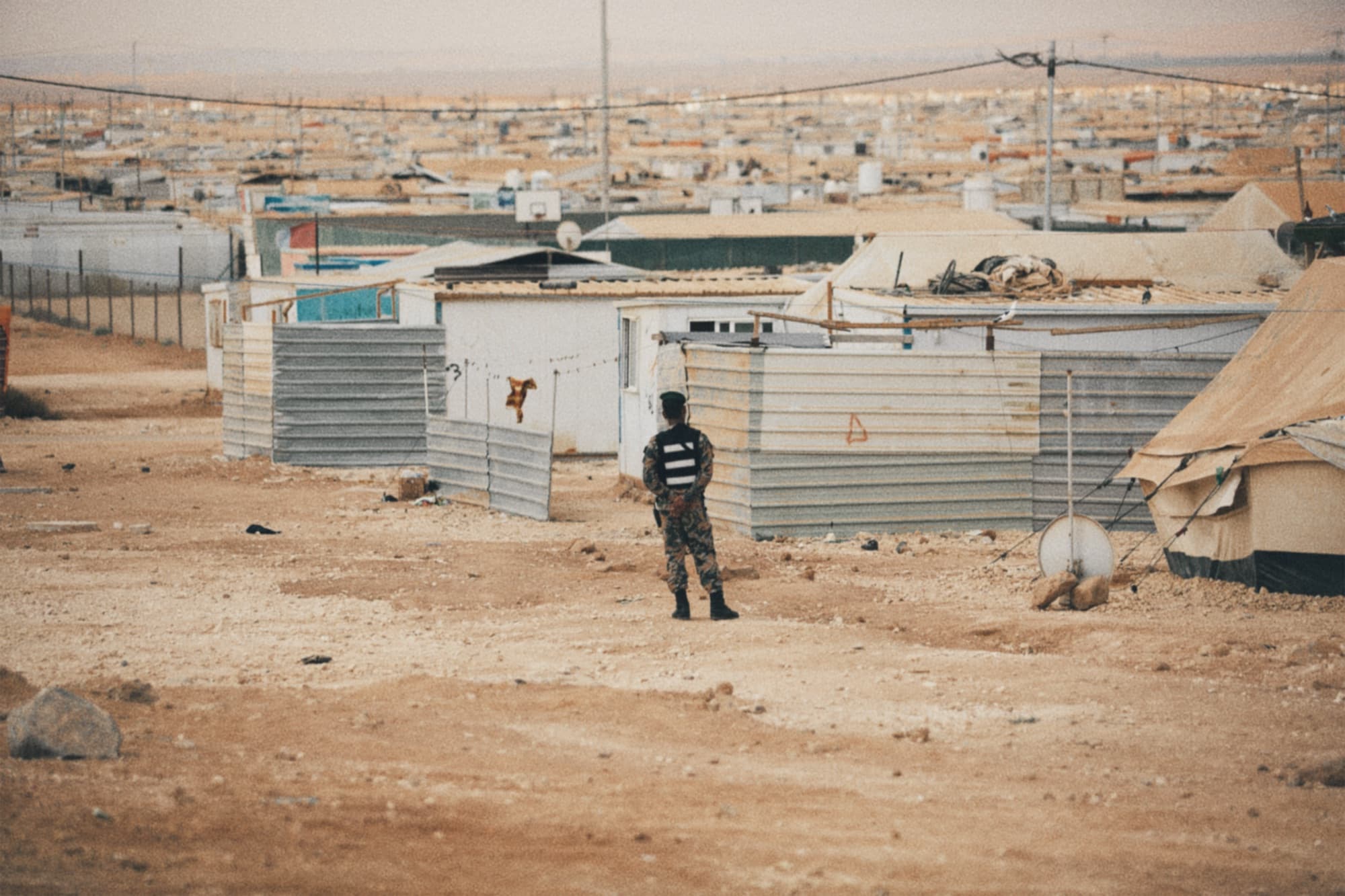 A person walking between shelters in a camp