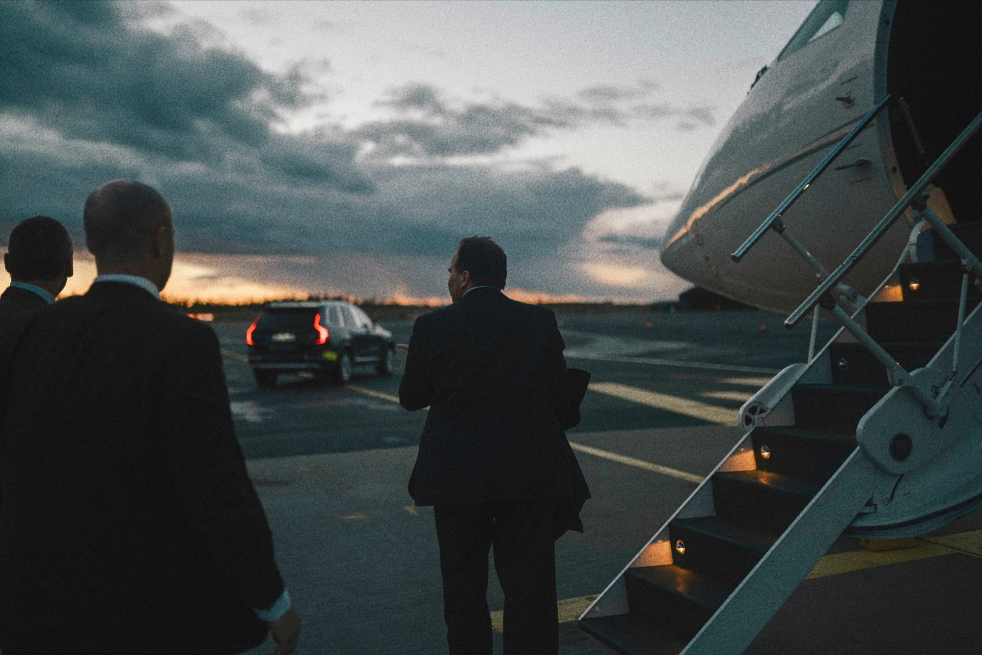 A delegation beside an aircraft at dusk