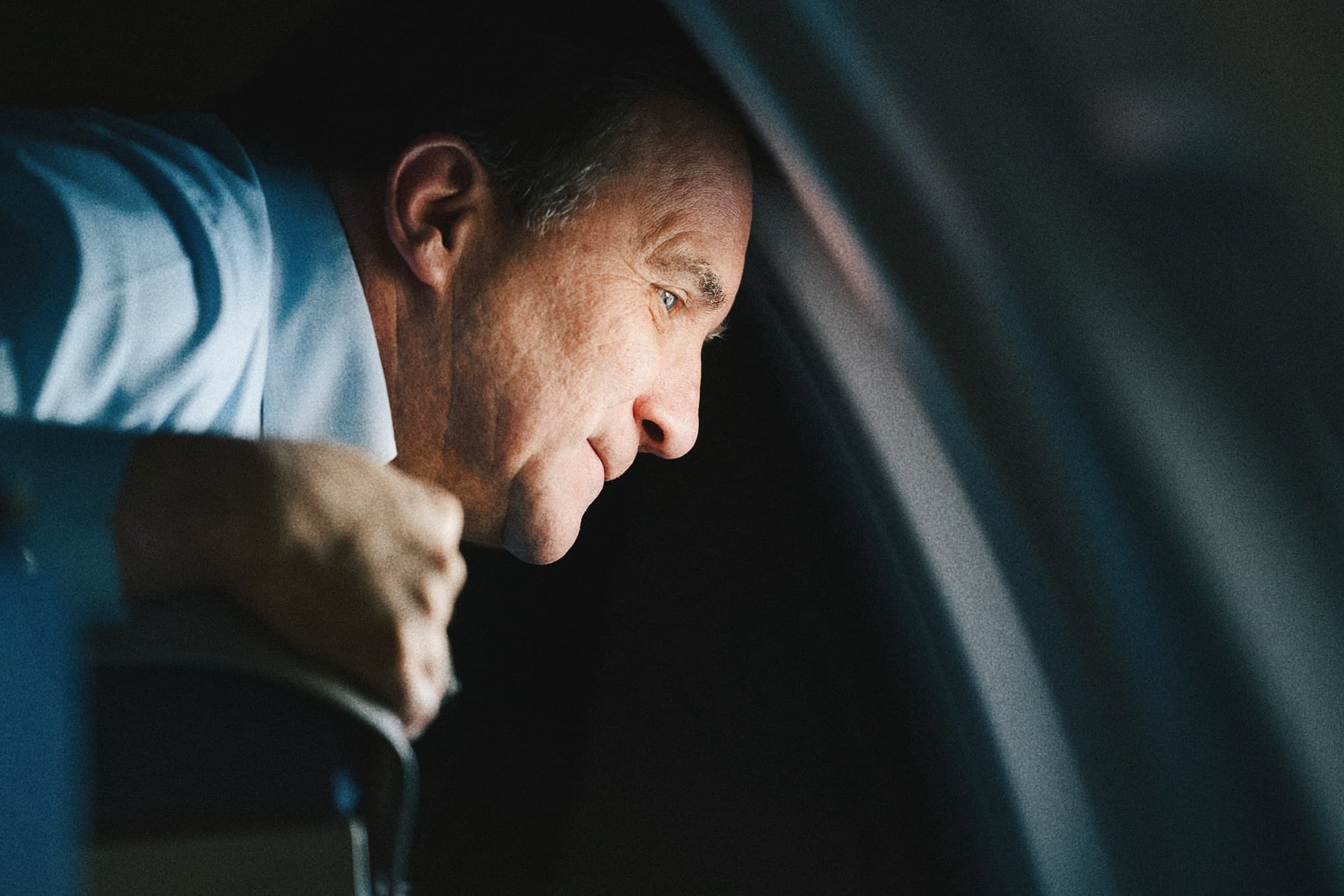 A close-up of a passenger looking out of an aircraft window