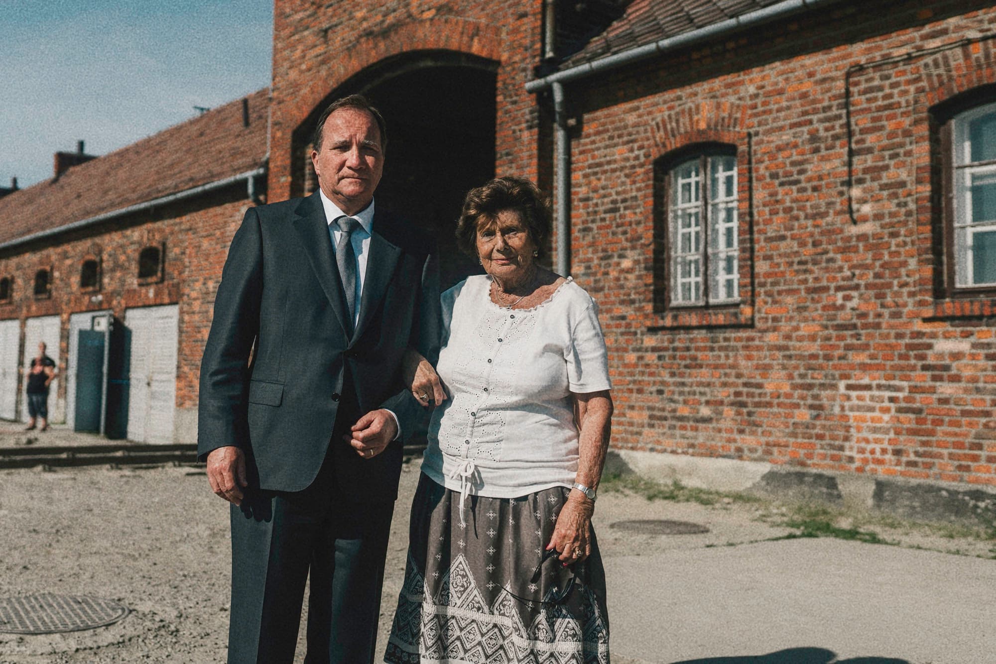Two visitors standing outside a brick building