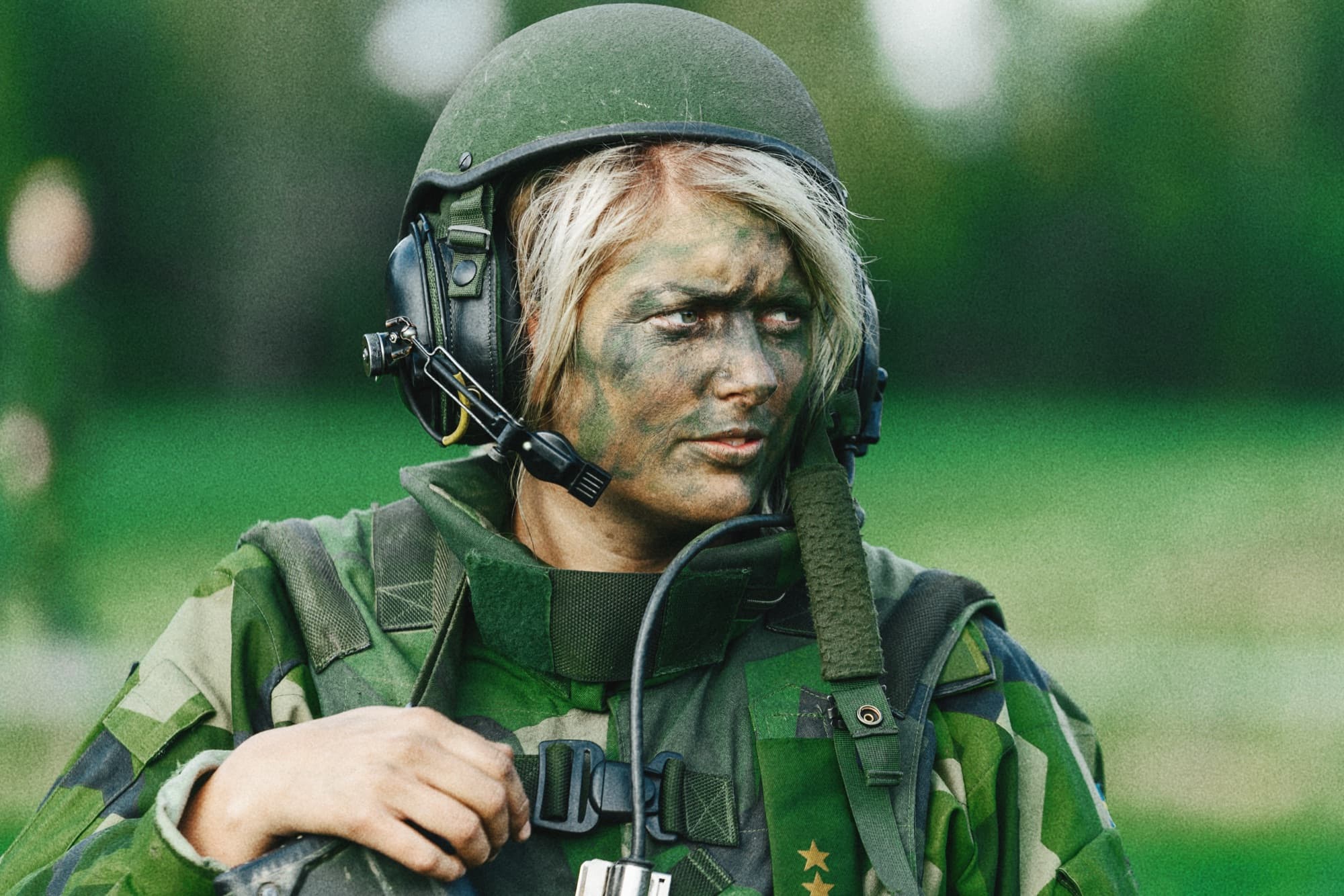 A soldier wearing a helmet and camouflage face paint