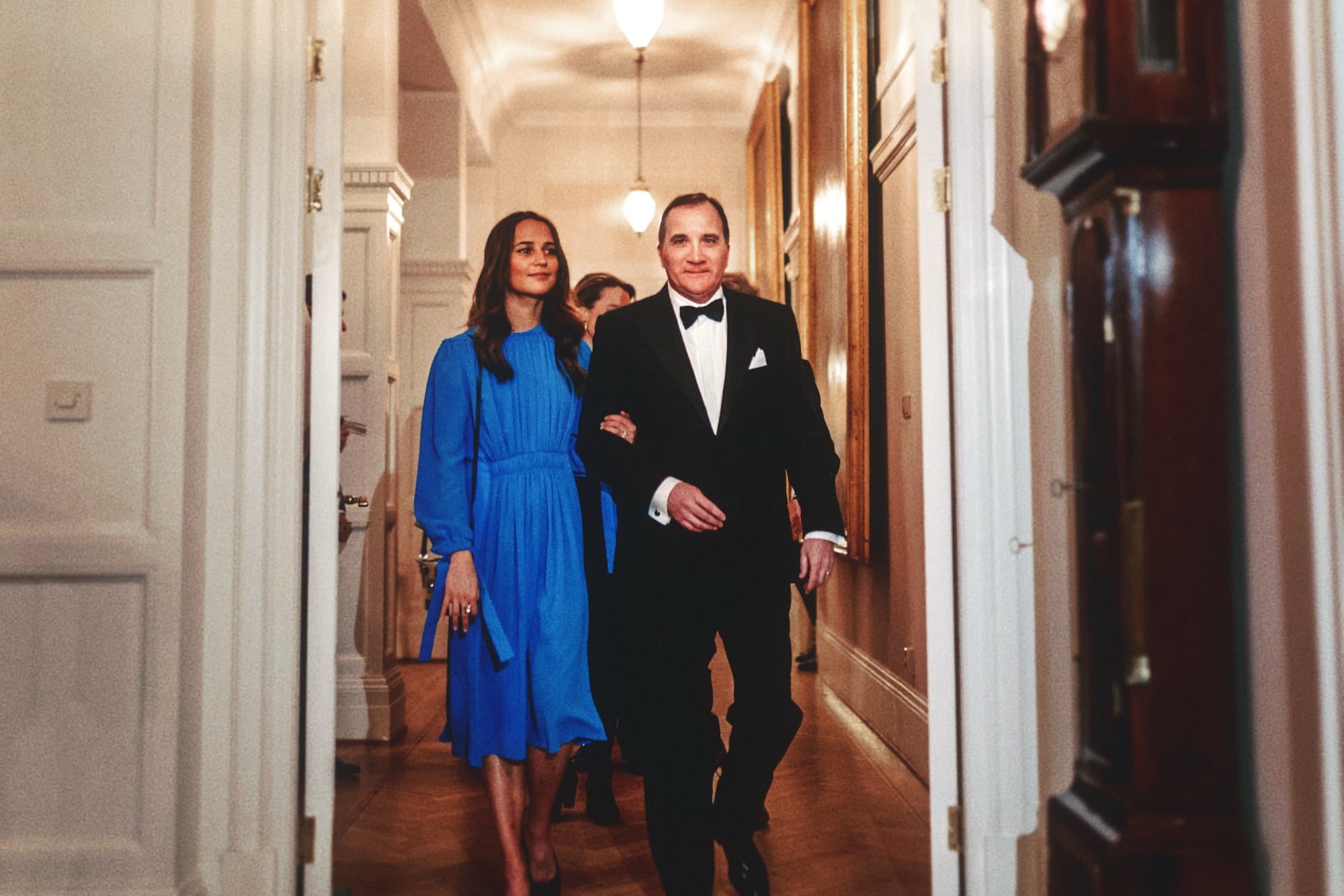 Two guests walking down a corridor in evening wear